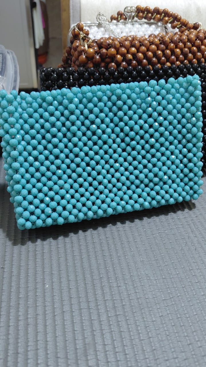 A selection of Delour hand-beaded clutches in turquoise, black and wood